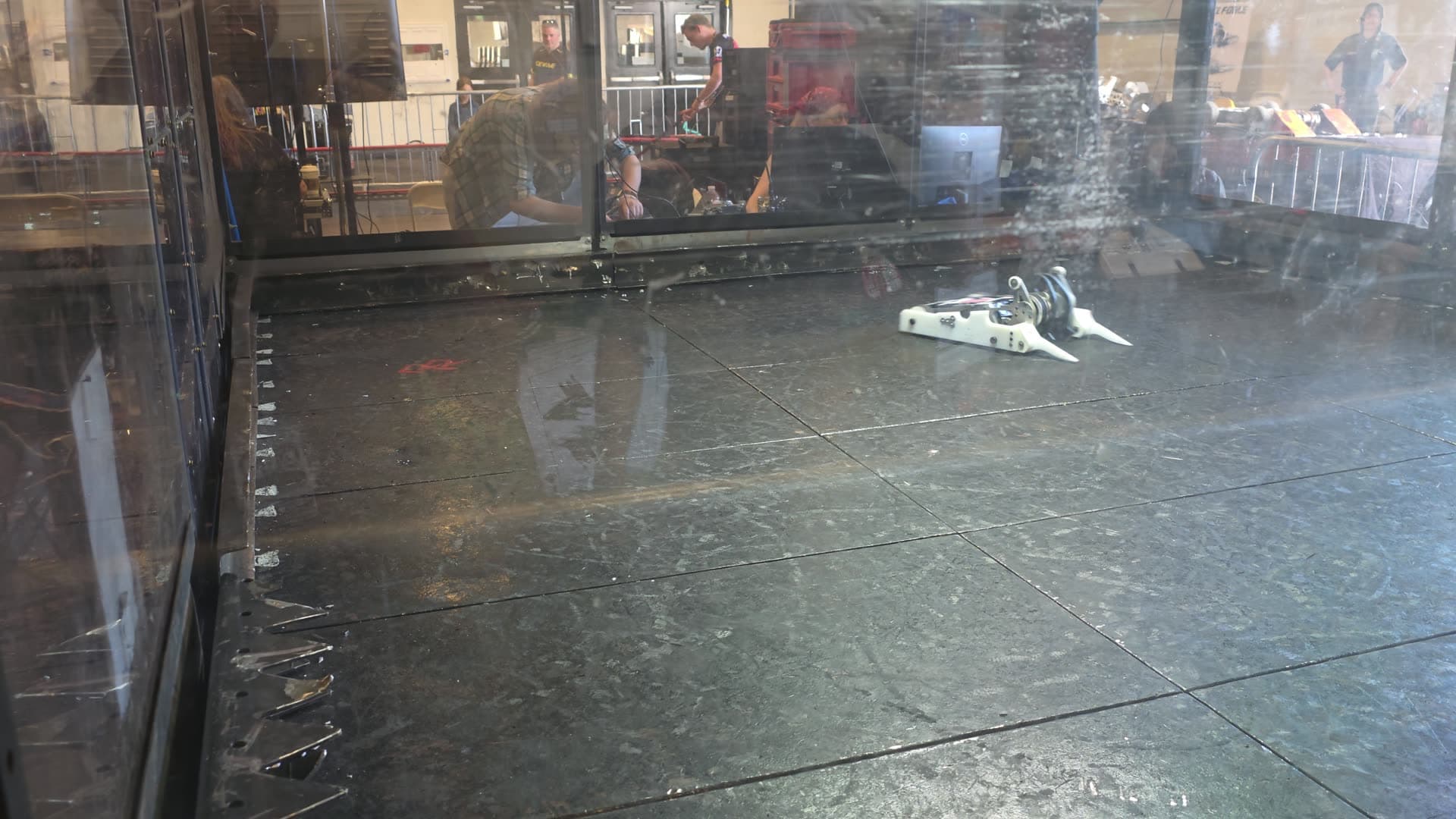 Shear Force driving in the arena during safety checks at Open Sauce 2026, seen through the polycarbonate wall